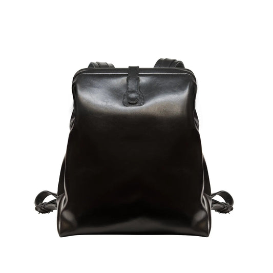 A black leather backpack with adjustable shoulder straps, grab handle, pin-buckle closure, and multiple pockets. Available in medium and large sizes to fit laptops up to 17 inches.