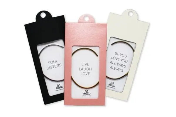A group of bracelets in packaging with the message Live Laugh Love. Adjustable, durable stainless steel bracelets engraved with a reminder of laughter and love. Width: 3mm. Available in silver, rose gold, gold.