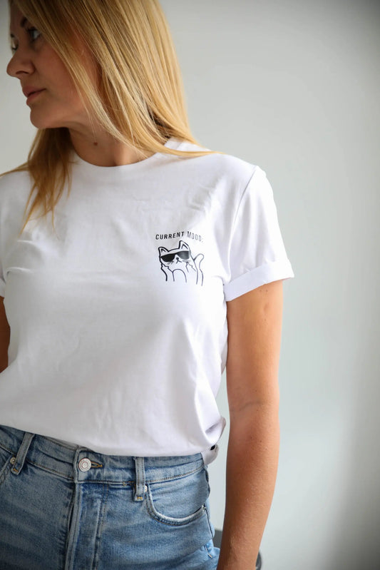 A woman in a white oversized t-shirt with a cat print, featuring 'Current Mood' text. Organic cotton, relaxed fit. Size chart available.