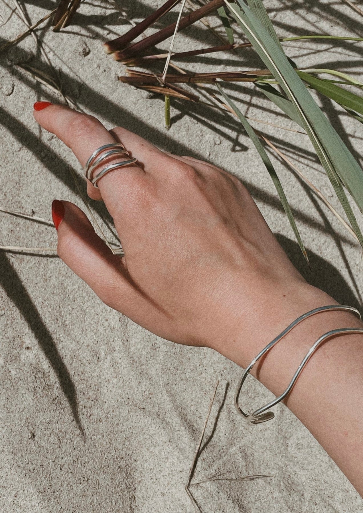 A hand adorned with double silver rings, showcasing stacked styling versatility. Hand-crafted from sustainable sterling silver in Lithuania and the Netherlands. Two-year warranty included.