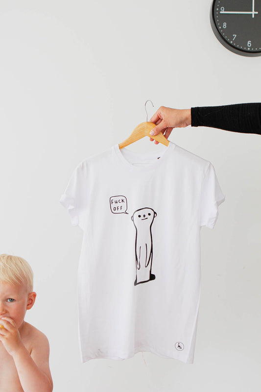 A hand holding an oversized white t-shirt featuring a sarcastic meerkat drawing. Product title: Meerkat f_ck off - White T-shirt. Dimensions: Width - 47 to 59 cm, Length - 68 to 76 cm.