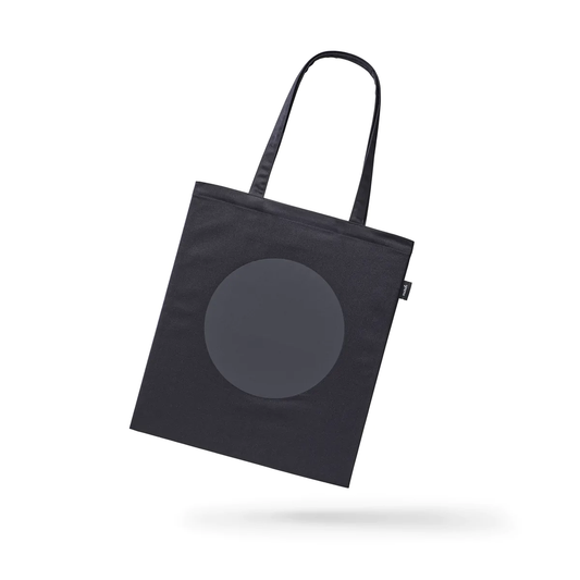 Reflective Tote DOT by MARCH Design Studio: Black tote bag with a grey circle print, designed for visibility and style. Features inside pocket, reflective print, and OEKO-TEX® STANDARD 100 certification.