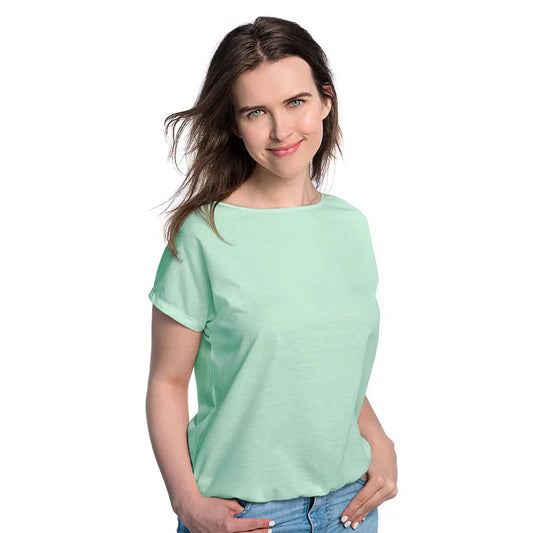 A woman in a mint green tan-through T-shirt, showcasing a comfortable fit for outdoor activities. Fabric allows healthy tanning with UVA rays penetration. Sizes: XS-XXL.