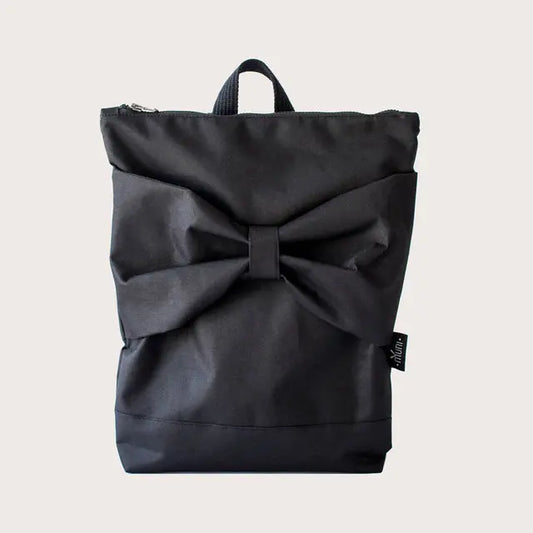 A black bow backpack, waterproof and stylish. Made of sturdy polyester with adjustable straps, zipper closure, and pockets for a 13 laptop. Height: 38 cm, Width: 34 cm.