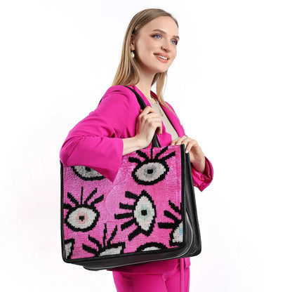 Woman in pink suit holding the Adeline Large Leather & Silk Tote Bag, showcasing its spacious design suitable for work or travel.