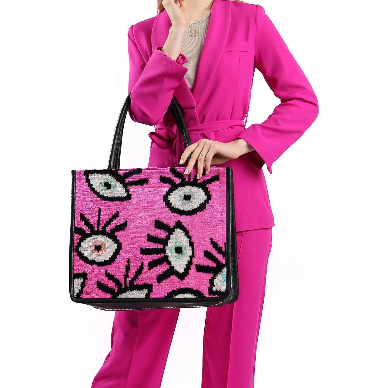 Woman holding Adeline Large Leather & Silk Tote Bag, showcasing its spacious design and zebra pattern, crafted from hand loomed silk and leather.