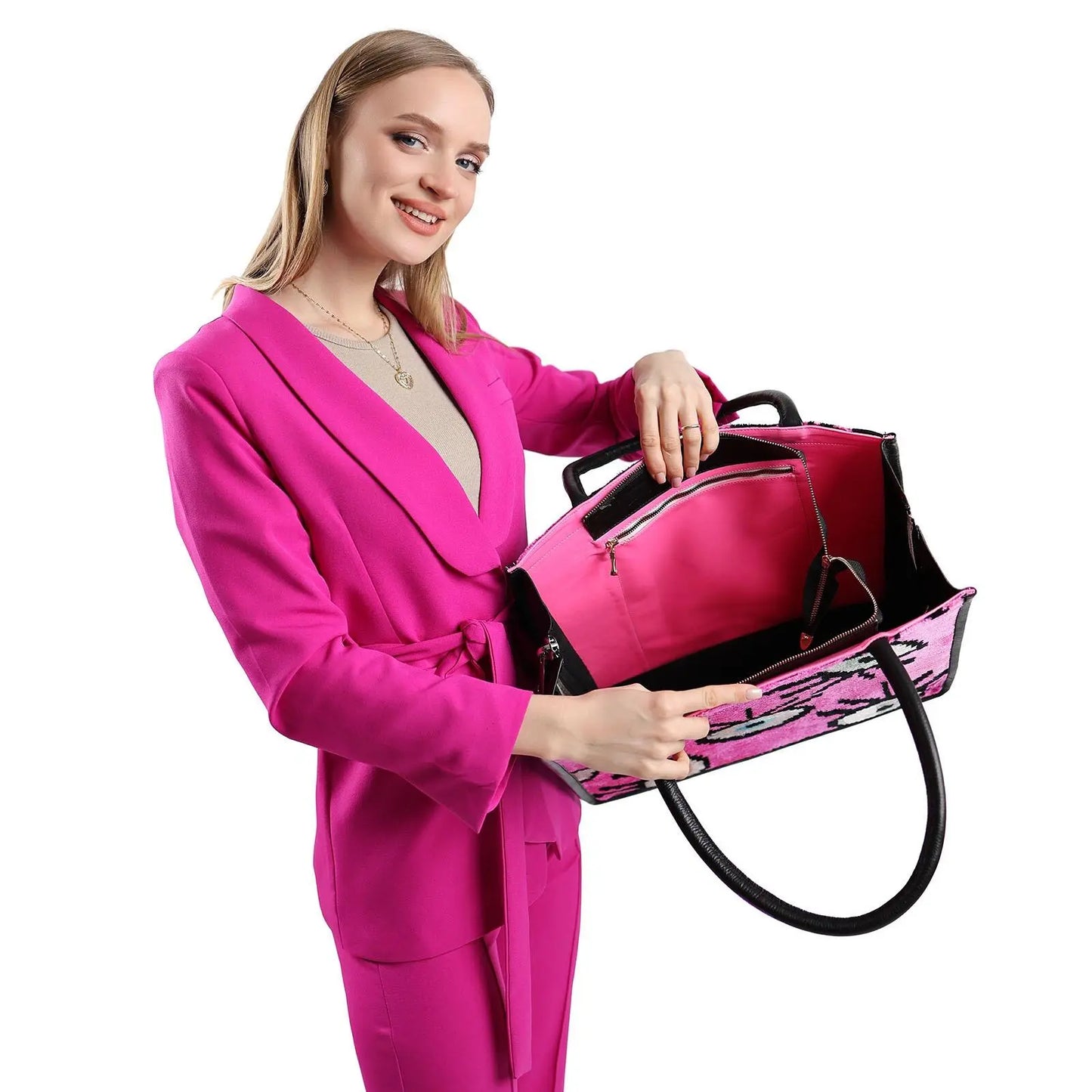 Woman in pink suit holding the Adeline Large Leather & Silk Tote Bag, showcasing its spacious design and craftsmanship.