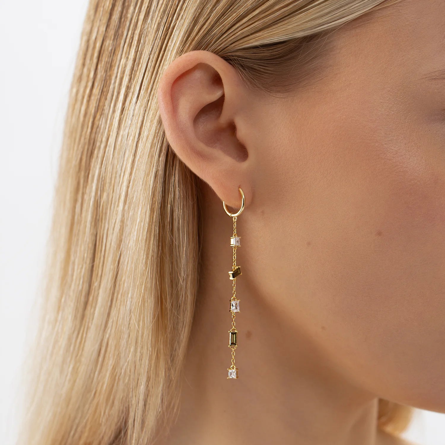 Close-up of a woman's ear wearing Hoop Earrings CASCADE in gold, showcasing elegant, sustainable design with 18k gold plating and hypoallergenic materials.