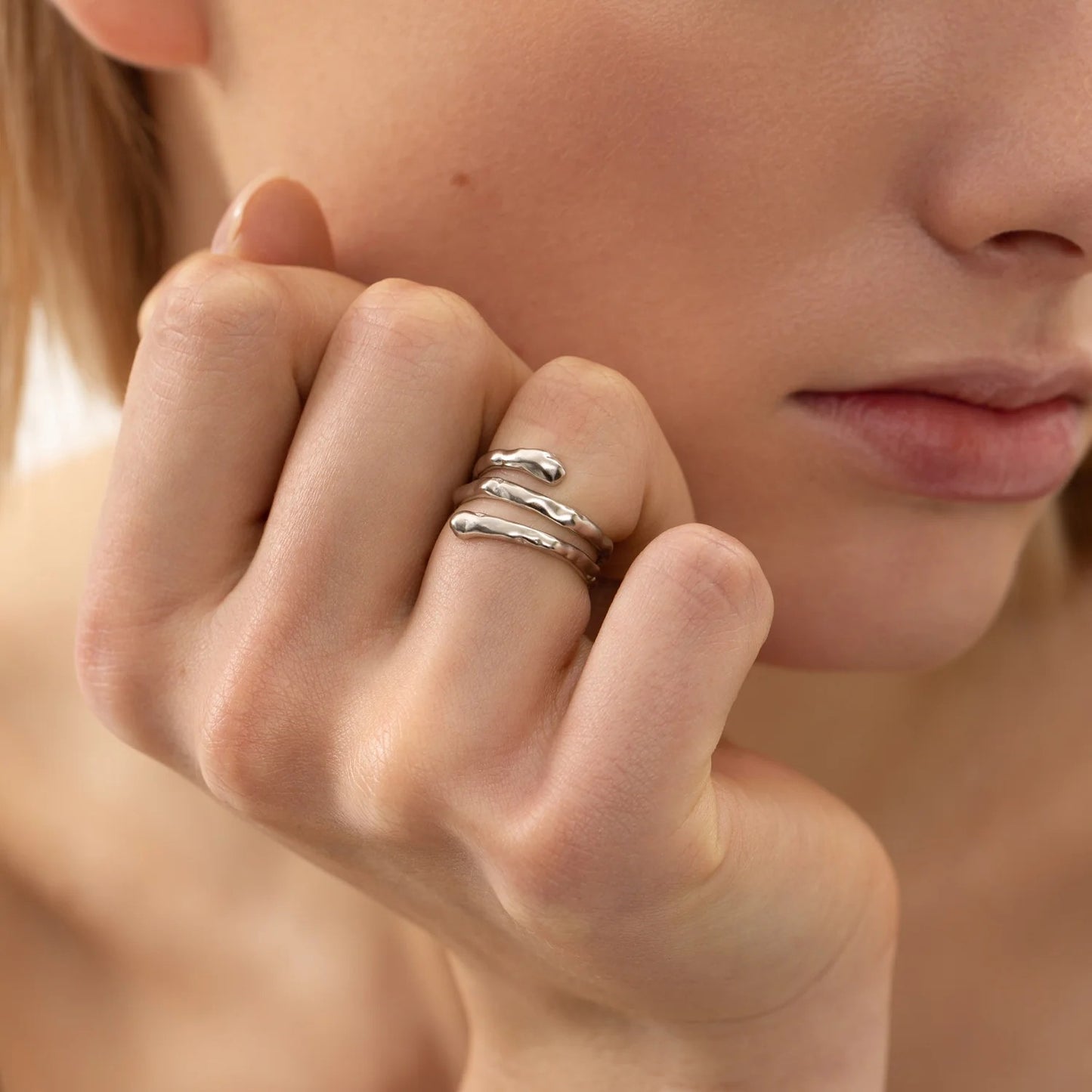 A close-up of a woman's hand wearing Resizable Ring SPIRAL - Silver, made of 925 sterling silver, hypoallergenic, elegant, minimalist, and adjustable in size.