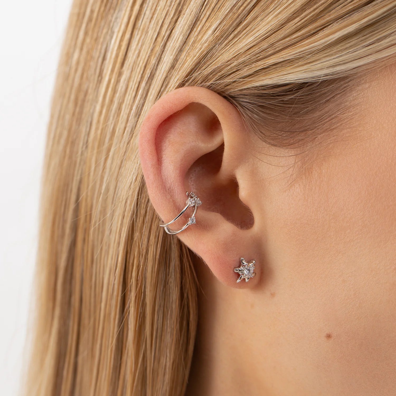 A close-up of a woman's ear adorned with a minimalist silver Single Ear Cuff ELYSIUM. Made from recycled silver, hypoallergenic, and elegant.