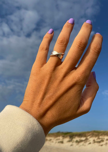 A hand with purple painted nails and a silver ring, showcasing the unique Andromeda Ring in sterling silver 925. Hand-crafted with care, each ring is a cosmic dream come true.