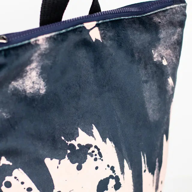 Close-up of a Watercolor backpack with velvet top and navy blue polyester bottom. Features adjustable straps, zipper closure, and pockets for a 13 laptop. Dimensions: 38cm x 34cm.