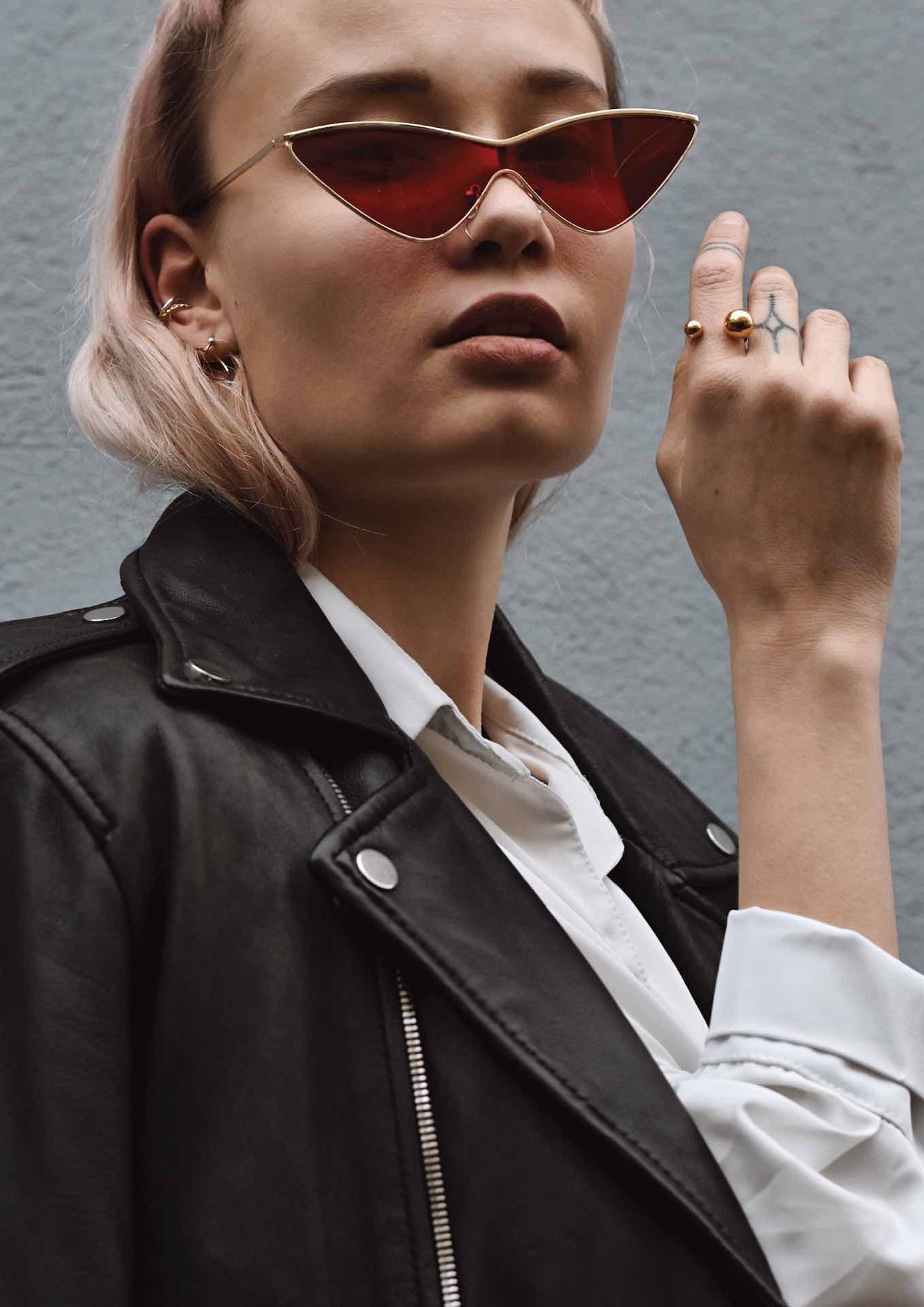 A woman wearing red sunglasses, a close-up of a nose and lips, and a hand with a tattoo, showcasing the Big Bomb Multisize Ring in Gold. Handmade in Lithuania, featuring 24K gold plating on sterling silver, with hollow bubbles on a band.