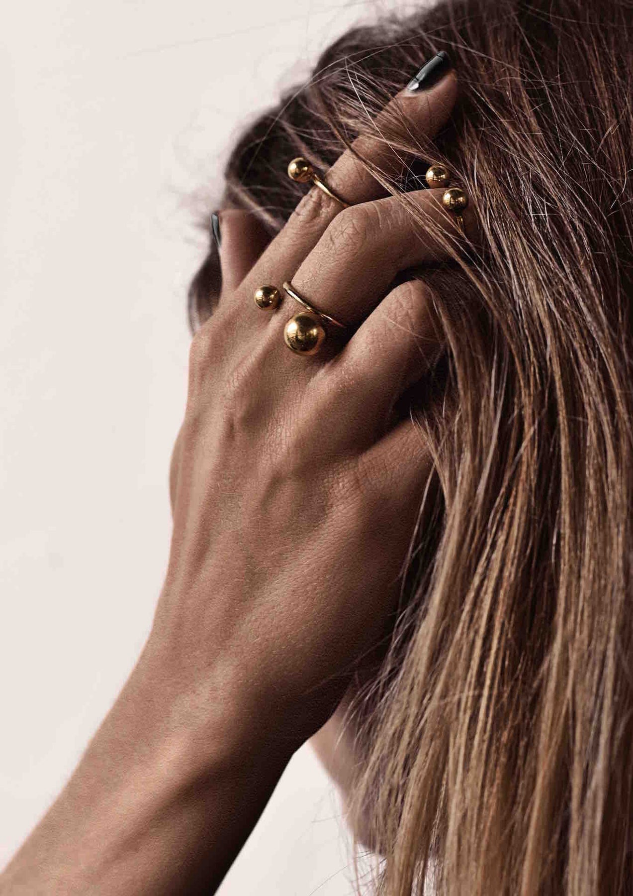 A woman with a gold plated bomb ring on her finger, showcasing a 6mm and 10mm hollow bubbles design on a 1.8mm band. Hand-made sustainably in Lithuania.