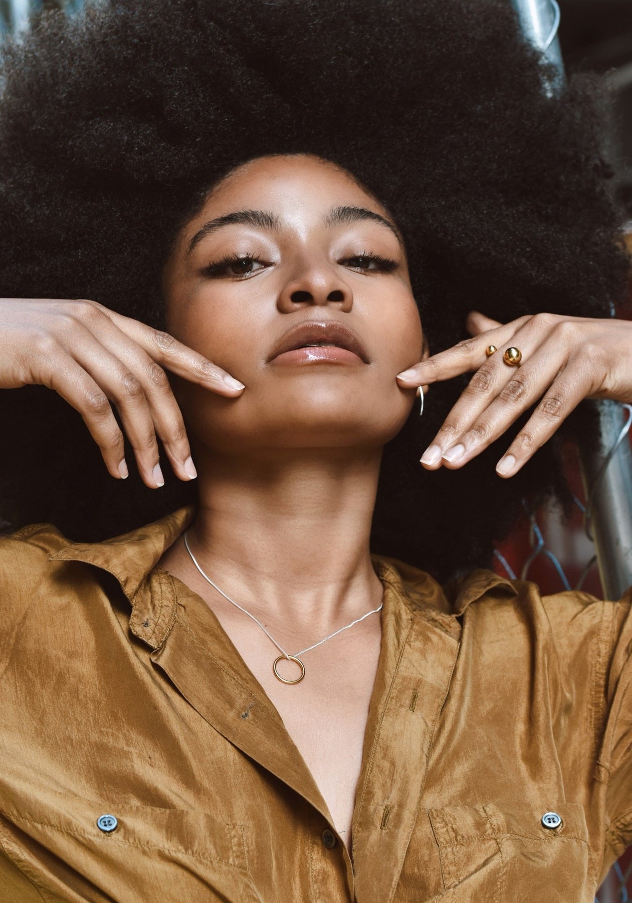 A woman with her hands on her face, wearing a Gold plated bomb ring. Hand-made in Lithuania, this statement piece features 6mm and 10mm hollow bubbles on a 1.8mm band. Sizes: S, M, L.