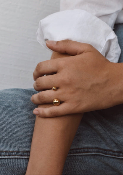 A person wearing a gold Big Bomb Multisize Ring, showcasing a close-up of the ring's intricate design with 6mm and 10mm hollow bubbles on a 1.8mm band.