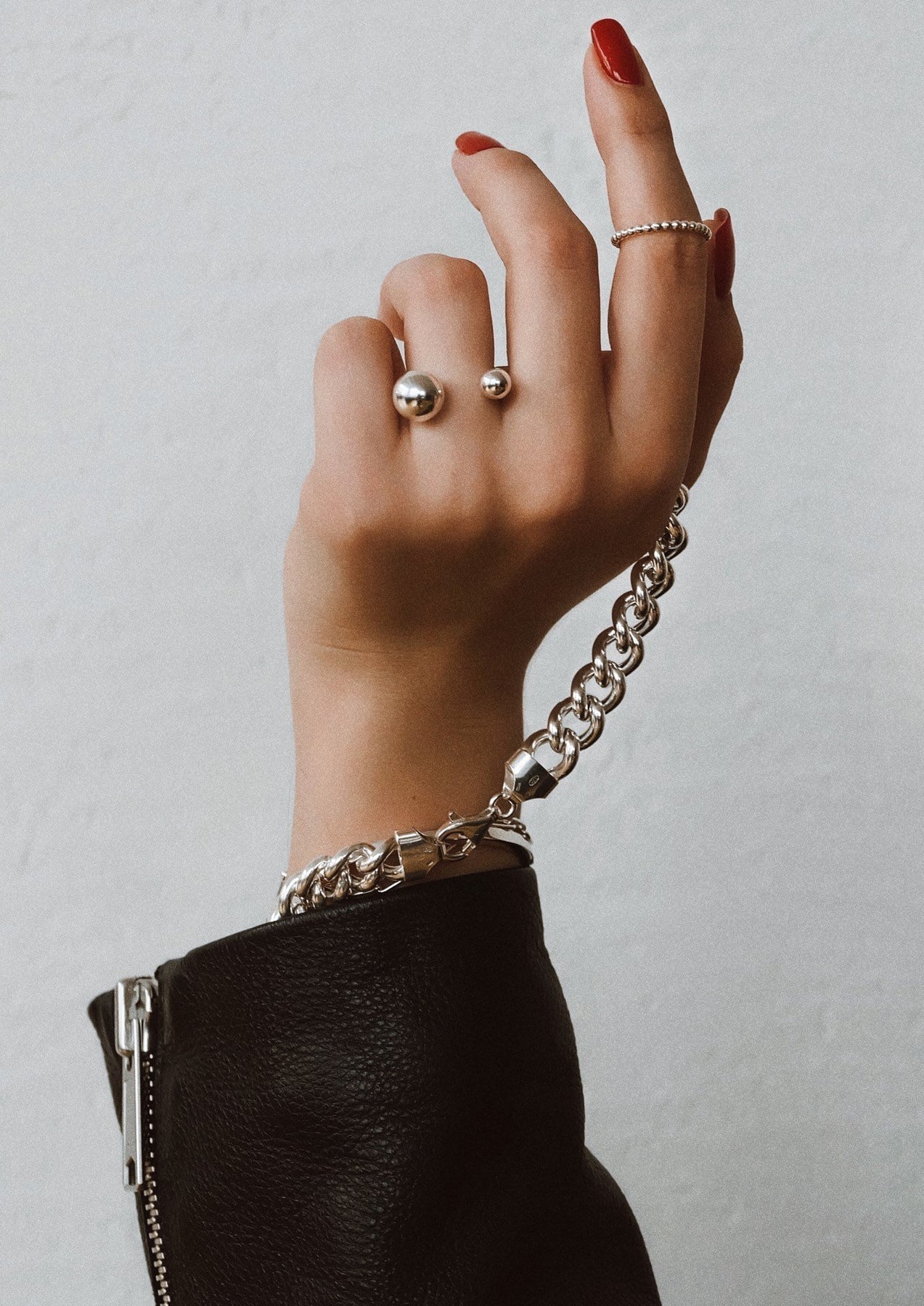 A hand wearing a Big Bomb Multisize Ring in Silver, showcasing a 6mm and 10mm hollow bubble design on a 1.8mm band. Handcrafted in Lithuania from sterling silver.