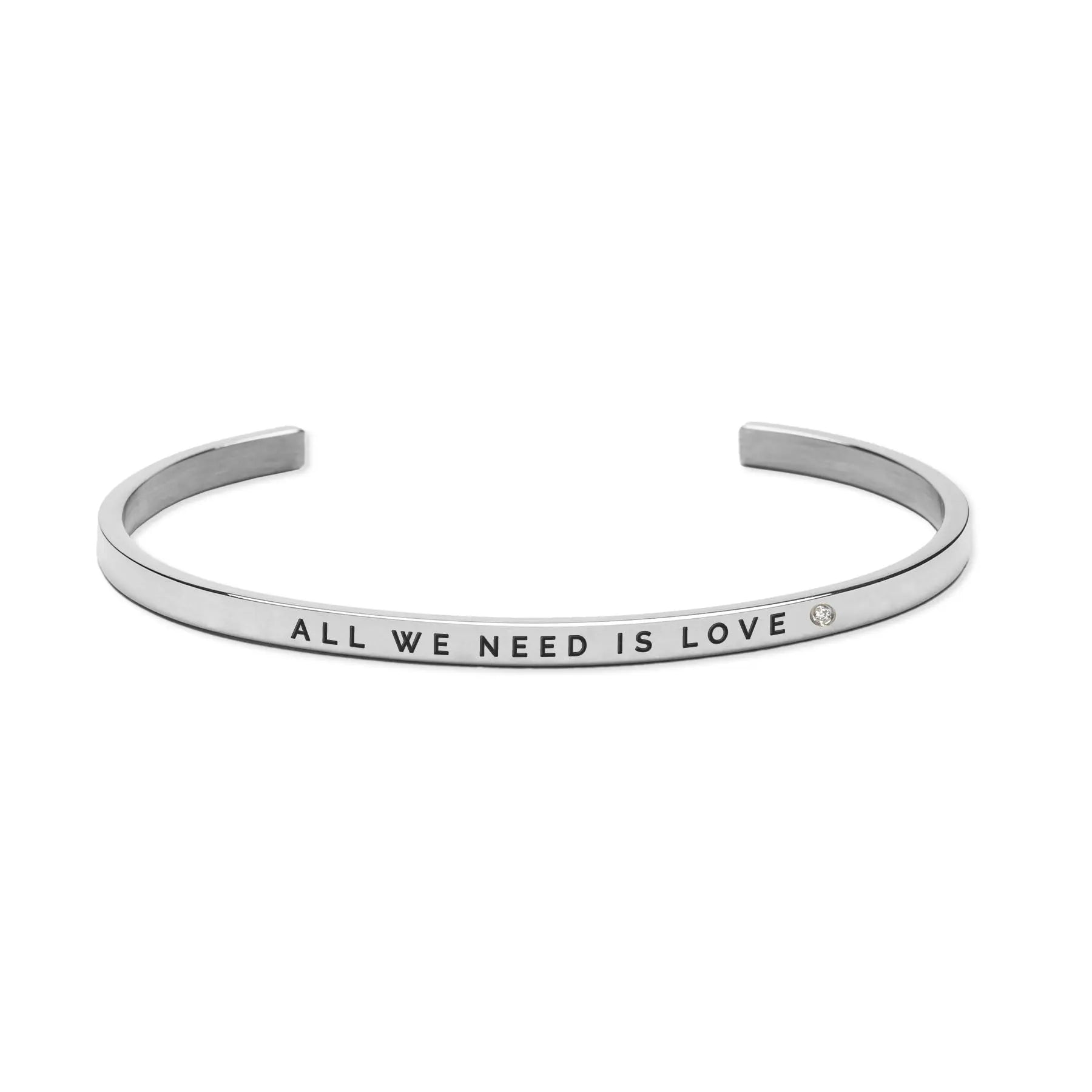 A silver bracelet with engraved words All We Need Is Love, symbolizing love's universal power and connection. Durable, adjustable, and elegantly crafted from stainless steel for lasting wear.