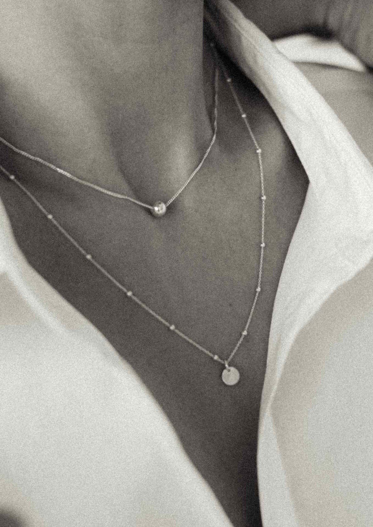 A woman wearing the Bubble Necklace - Gold, a sterling silver piece with 24kt gold plating bubble. Handmade sustainably in Lithuania, 40 cm chain length, 6 mm hollow bubble.