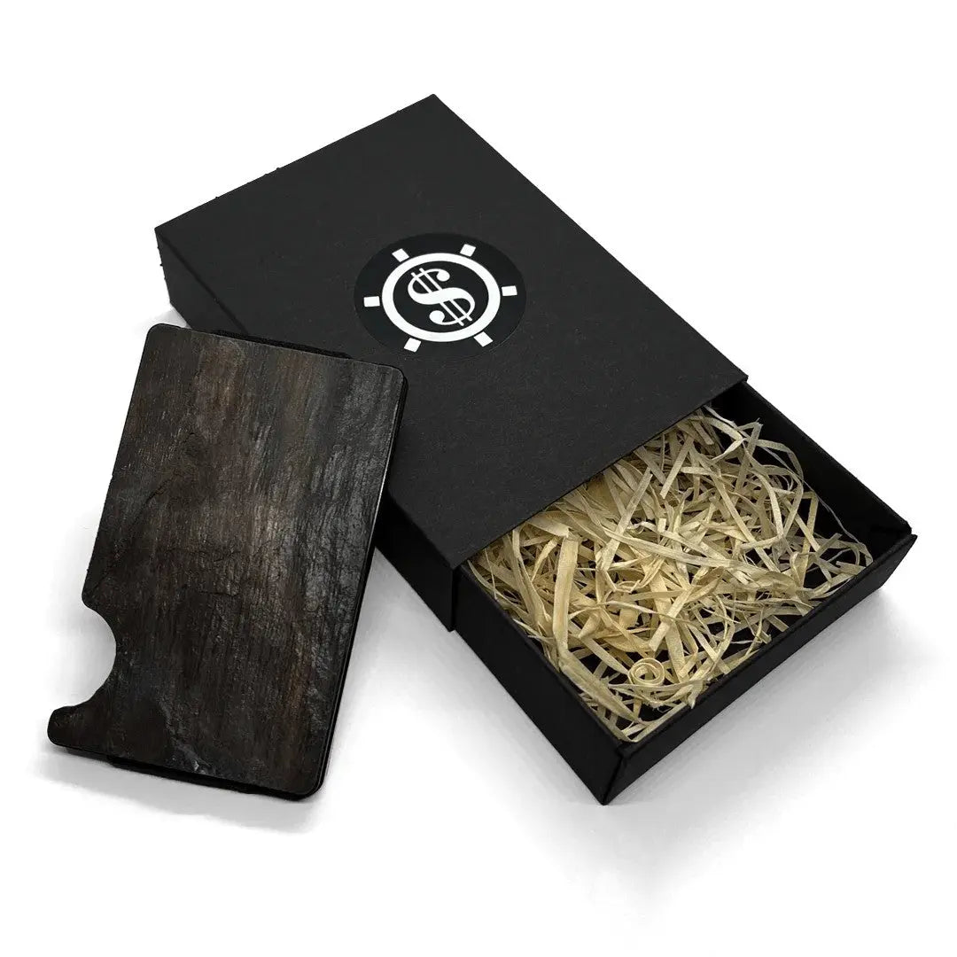 A black box with a wooden object inside, featuring a sleek Card Holder with RFID Blocking - Charcoal Black by Seif Design, crafted from natural slate stone.