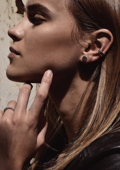 Woman wearing a Flat Ear Cuff in Sterling Silver, showcasing close-up of ear and face. Handmade in Lithuania, no piercing needed. Sleek, sustainable design for everyday wear.