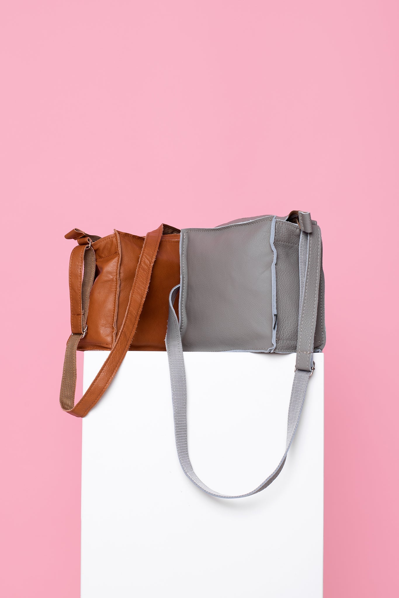 Handmade Folk 1 shoulder bag in light grey leather, crafted from furniture industry leftovers, showcasing a unique design with a strap. Made in Estonia for durability and eco-friendliness.