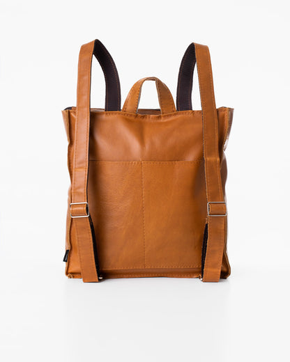 Handmade Folk 2 leather backpack in caramel, crafted from furniture industry leftovers. Features one large pocket and two smaller open pockets. Made in Estonia, each bag is unique. Dimensions: 30 x 30 x 9.5 cm.