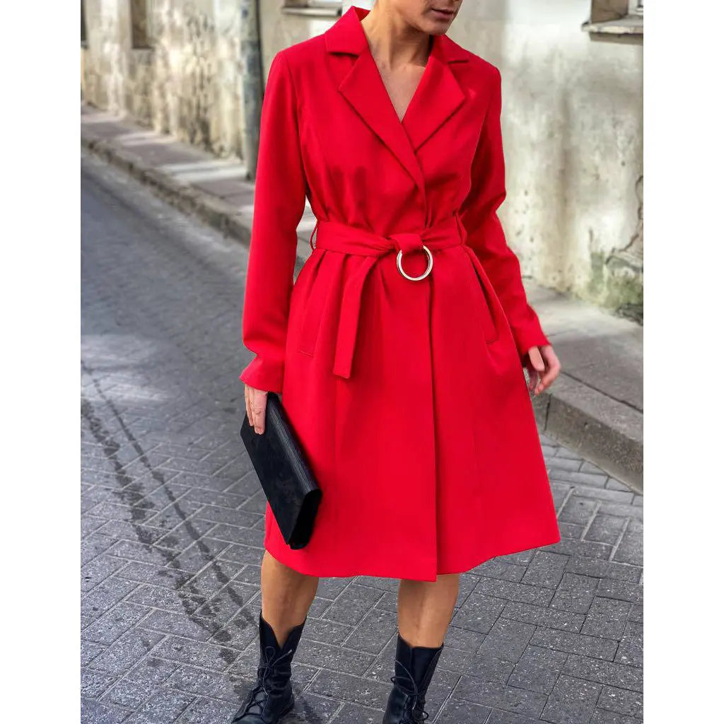 A woman in a red coat holding a black bag, showcasing a Large Glossy Wood Clutch. Handmade from leather and matte black wood, featuring a unique birch panel design. Dimensions: 16.5 cm x 27.5 cm x 4 cm.