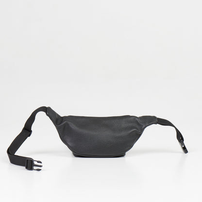 A black leather waist bag with adjustable strap. Features main and front zippered pockets, and a back compartment. Crafted in Europe from natural leather. Dimensions: 30 x 13 x 10 cm.