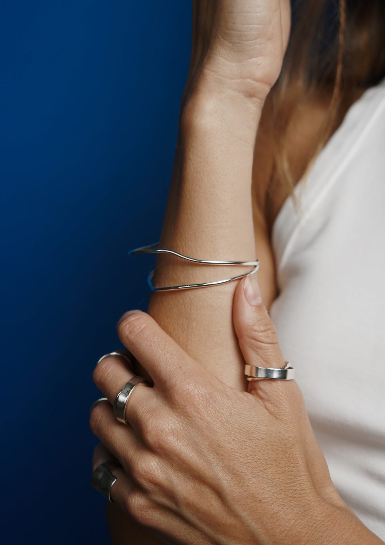 A woman's hand adorned with the unique Milky Way Ring in sterling silver, showcasing intricate details and cosmic inspiration. Hand-crafted in Lithuania with sustainable packaging and a two-year warranty.