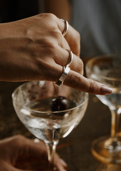 A hand wearing a unique Milky Way Ring in sterling silver, showcasing intricate details and cosmic inspiration. Hand-crafted with care, featuring a spinning design for dreamers.