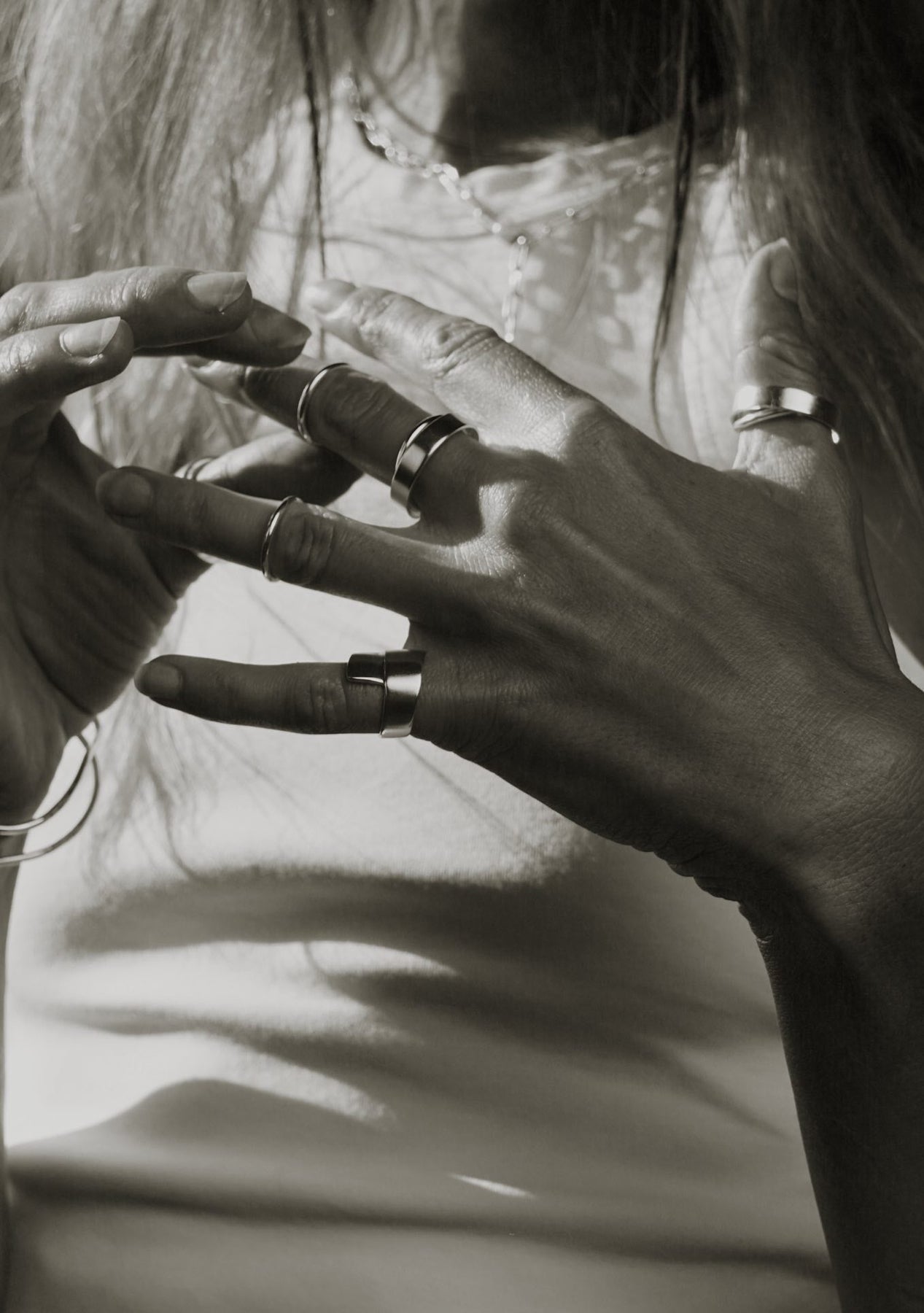 A close-up of a woman's hands showcasing the Milky Way Ring in sterling silver, symbolizing cosmic dreams and handcrafted uniqueness. Dimensions: 2.9mm thickness, 7.5mm height, 4.2-4.55g weight. Hand-made sustainably in Lithuania.