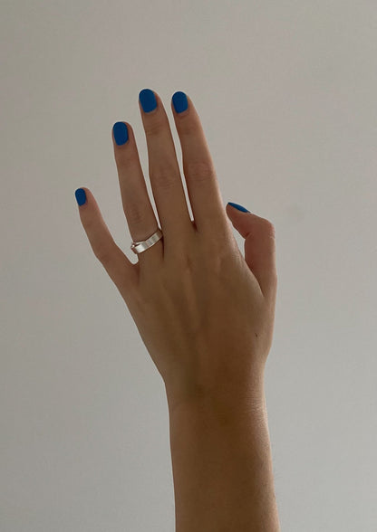 A hand with a silver Milky Way ring, showcasing blue painted nails, sterling silver 925 material, 2.9 mm thickness, 7.5 mm height, 4.2-4.55 g weight, and sustainable packaging.