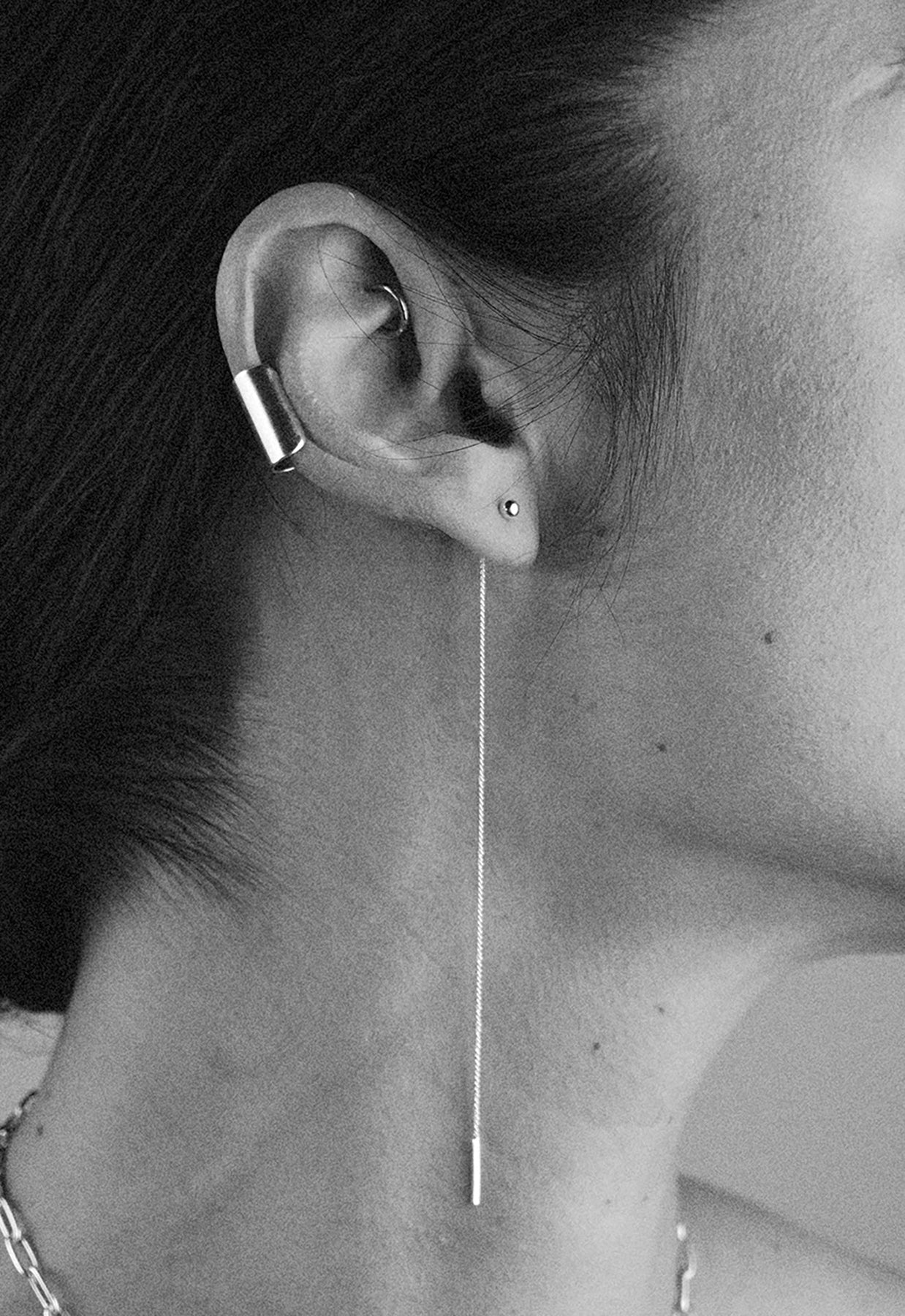 A close-up of Pin Up Threader Chain Earrings in Sterling Silver, showcasing a woman wearing the delicate chain earrings threaded through her ears.