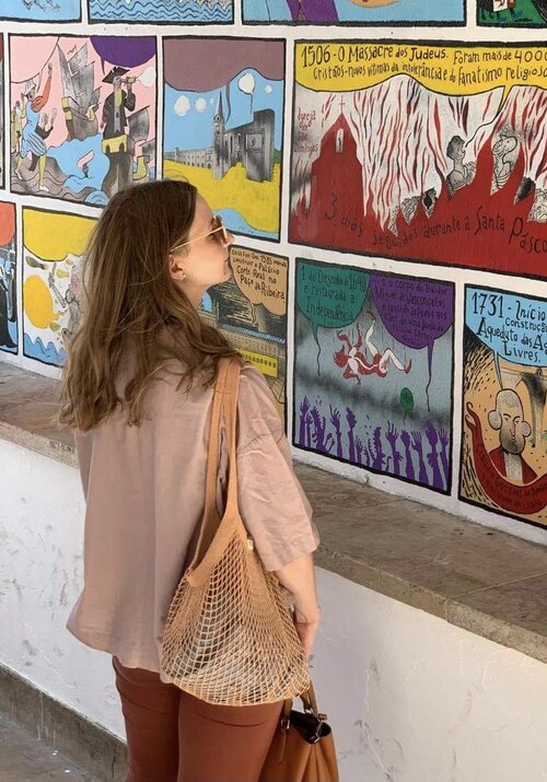 A woman with a brown shirt gazes at paintings, holding a string bag. Close-up of a purse. Plastic-free Net Bag, versatile and eco-friendly for shopping, gym, and beach.