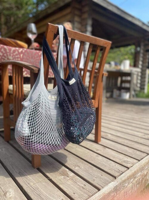 A sustainable Plastic-free Net Bag on a chair, showcasing its spacious design and sturdy handles. Ideal for shopping, gym, and beach with 15 kg capacity. Made of 100% organic cotton. Size: 43 x 45 cm.