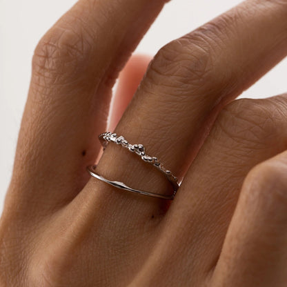 A close-up of a resizable Ring MIST in silver, showcasing a hand with a hypoallergenic sterling silver ring plated with rhodium. Elegant and minimalist for all occasions.