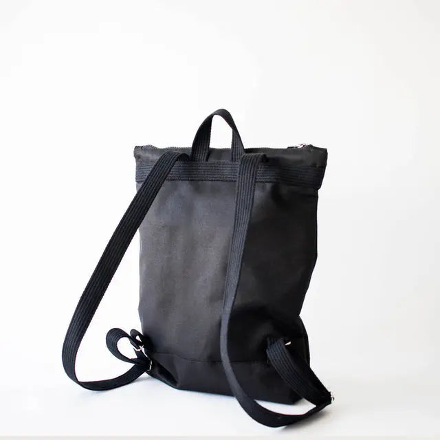 Black Bow Backpack with waterproof polyester, adjustable straps, zipper closure, inside pockets, and laptop compartment. Versatile, cute, and durable for work, park, or hike.