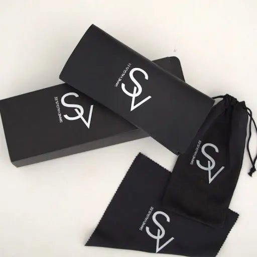 Black box with white text and cloth bags, showcasing CALIFORNIA Blue Light Glasses. Zero-power lenses for UV protection. Designed in Europe by Sinine Valgus for stylish eye care.
